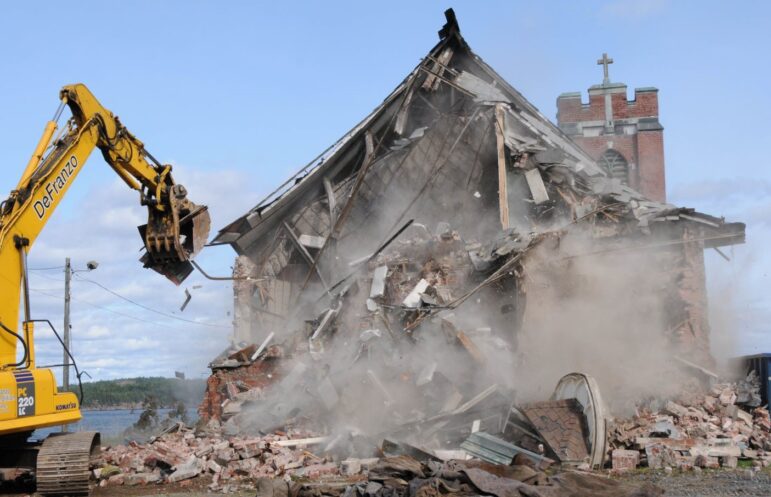 Construction crews knock down the church.
