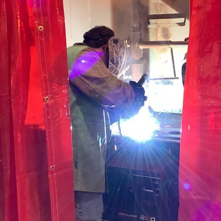 A student using a welding machine.