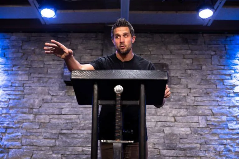 Travis Carey speaks during a church service.