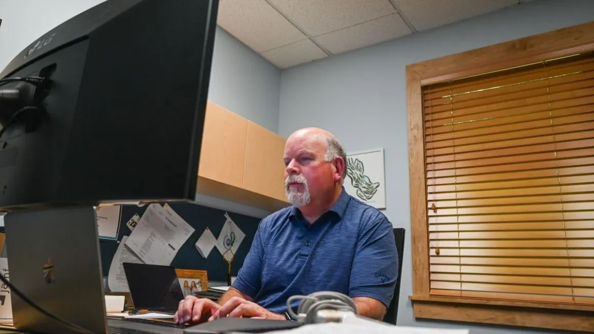 Mike Arsenault typing on his laptop.