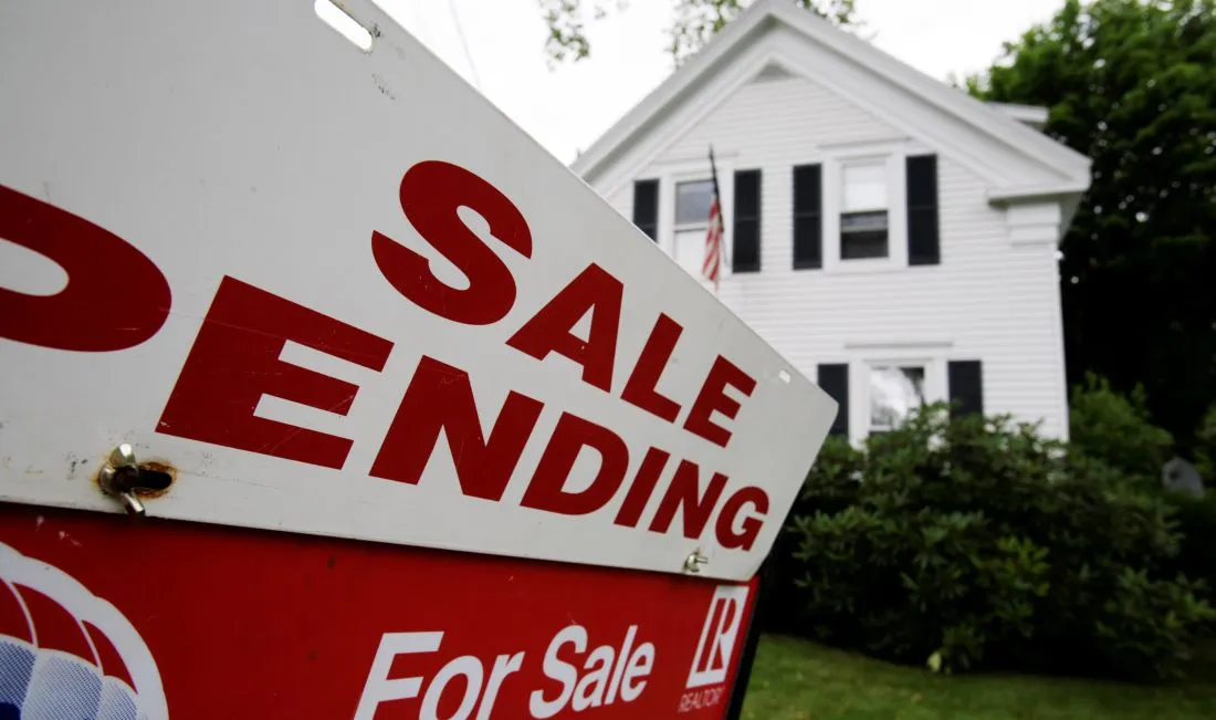 a real estate sign that reads sale pending in the front yard of a house