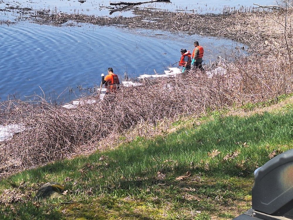 First responders use pads to clean up an oil spill in the Kennebec River.