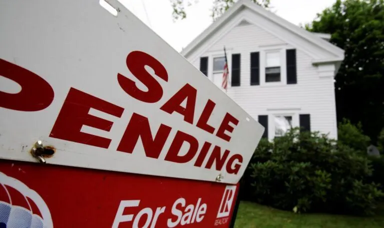 a real estate sign that reads sale pending in the front yard of a house