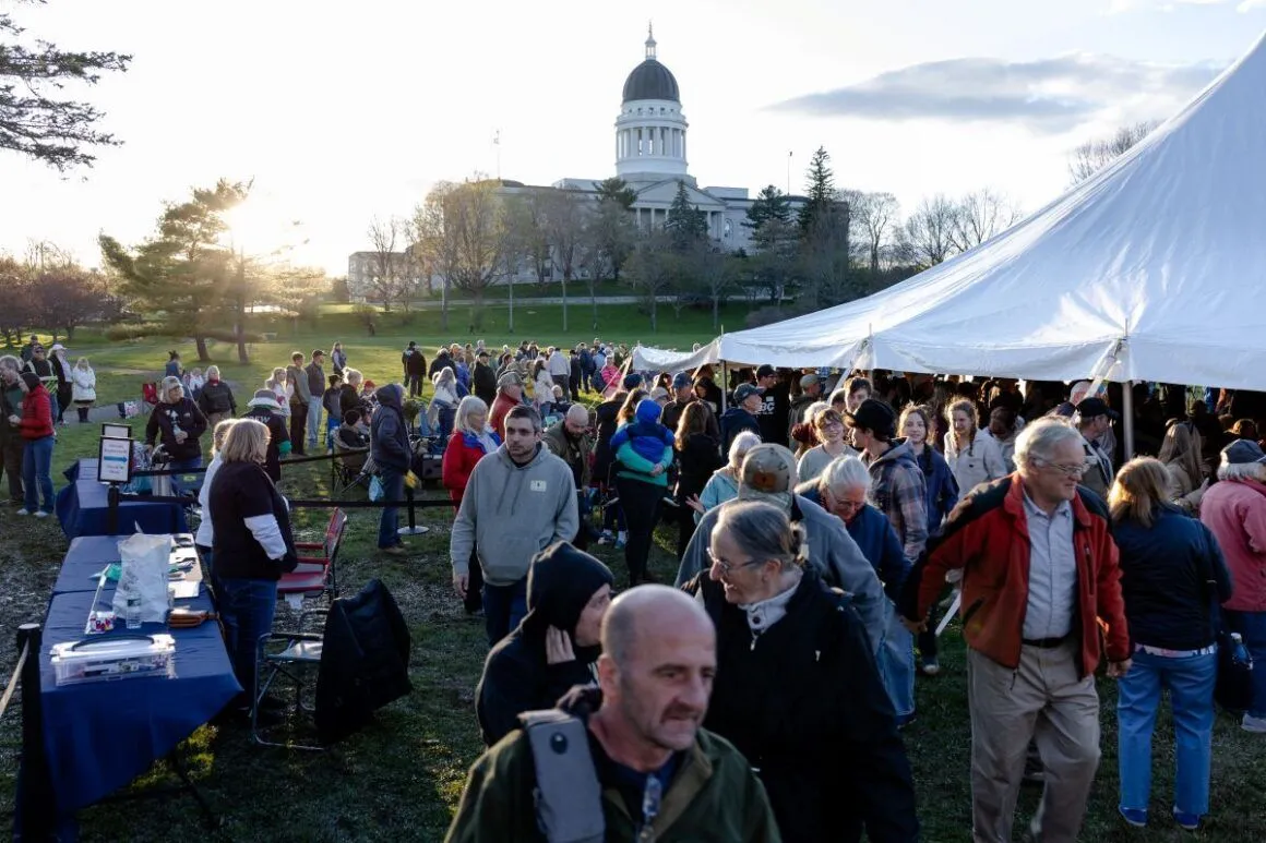 people walking around as part of the event with the state house in the background.