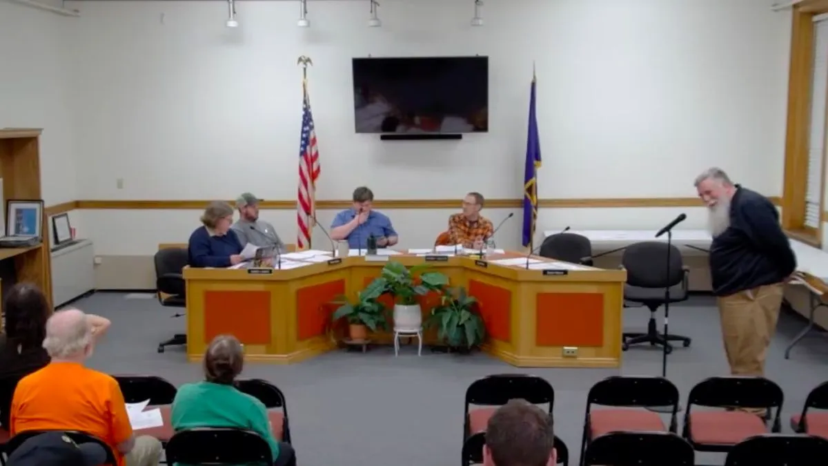 Members of the Skowhegan select board listen to John Youney.