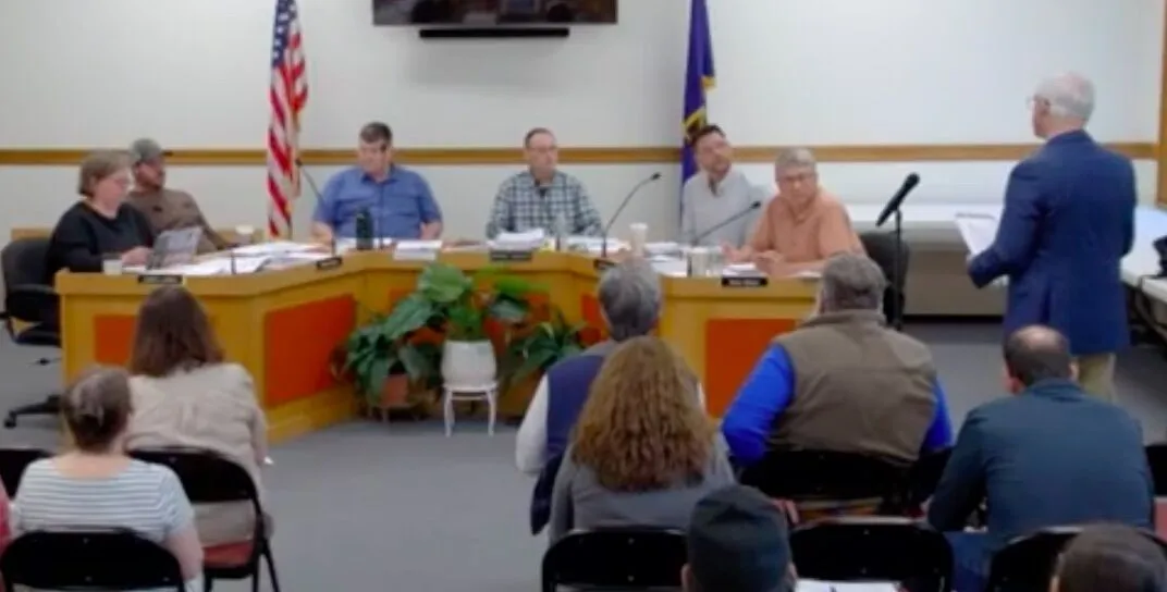 school board members listen to a speaker.