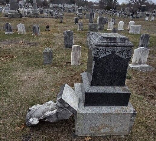 a damaged headstone in a cemetery.