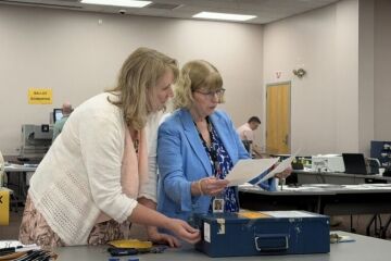 election officials looking at pieces of paper.