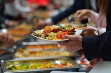a man holds a plate of buffet food