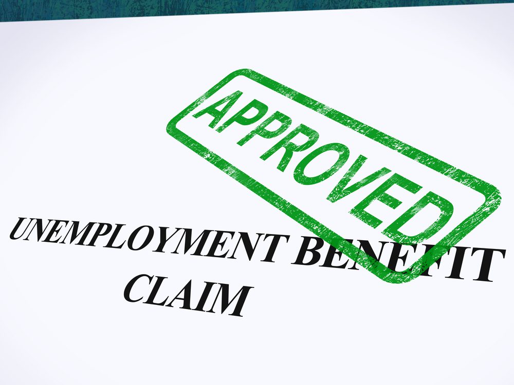 Stock photo of an employment benefits claim form that has been stamped by a green APPROVED ink stamp