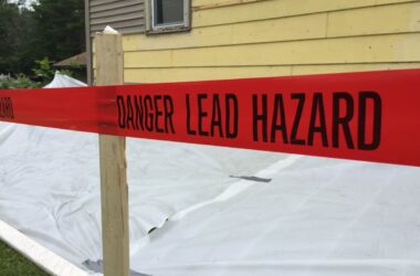 red tape that reads danger lead hazard is running along the perimeter of a house