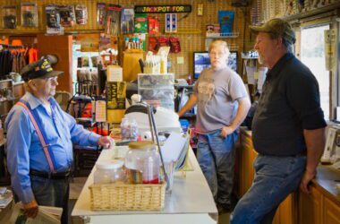 three men having a conversation in a general store