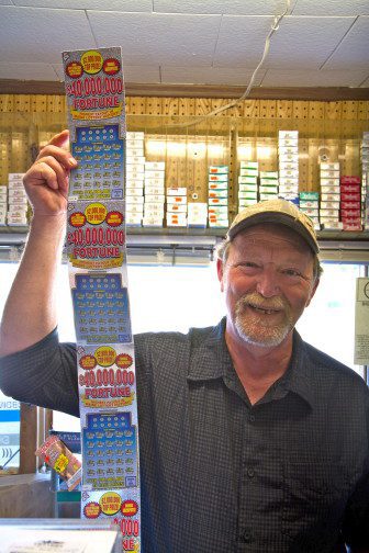 Waite General Store owner Wayne Seidl holding lottery tickets