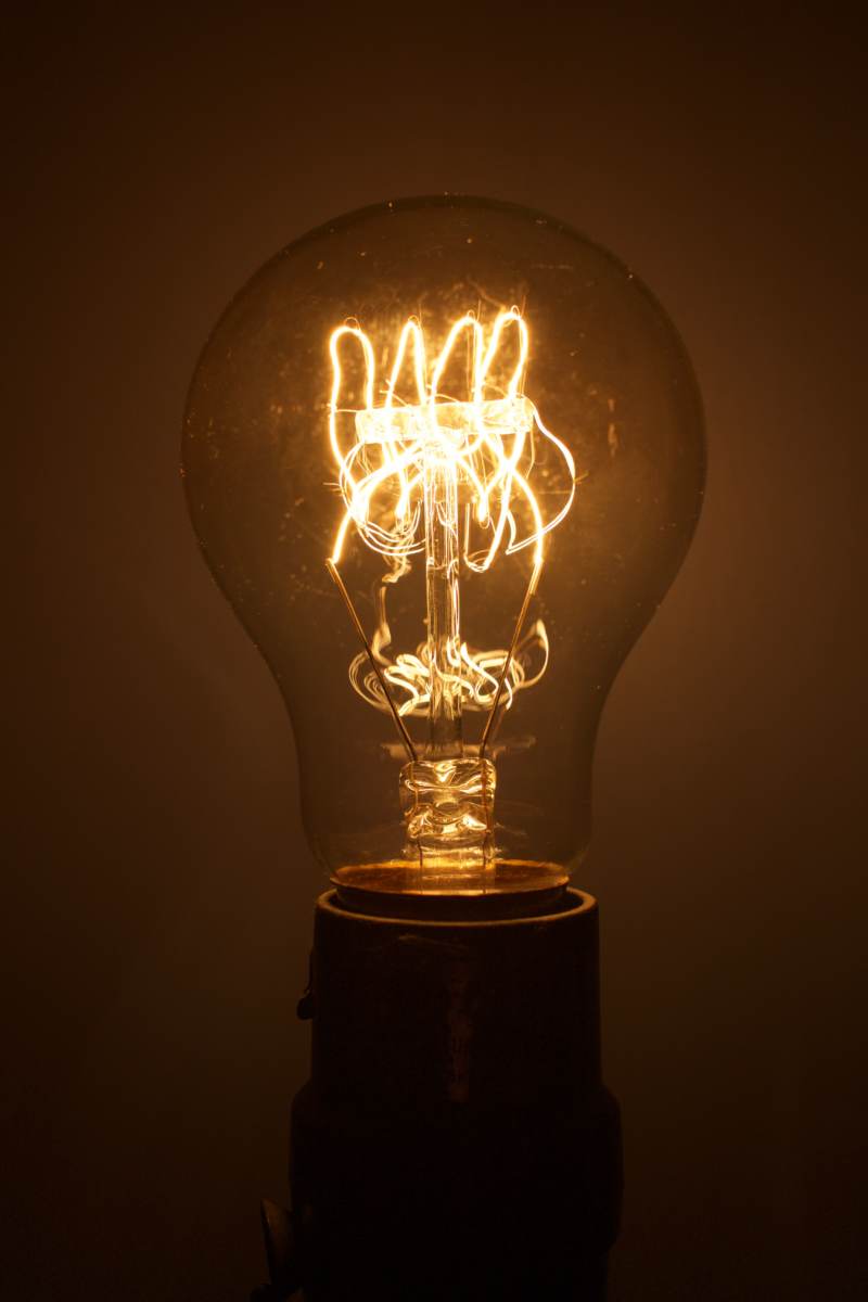 A light bulb turned on, with an editing filter applied to give the photo more of a bronze glaze
