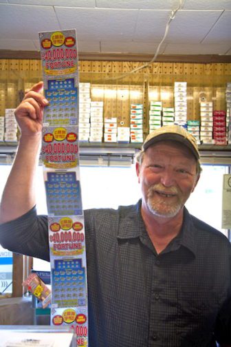 Waite General Store owner holds Maine lottery tickets.