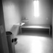 A black and white photo of the interior of an isolation cell at Maine State Prison.