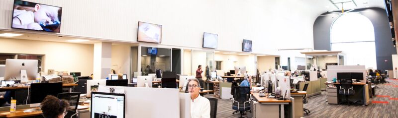 people working inside a newsroom