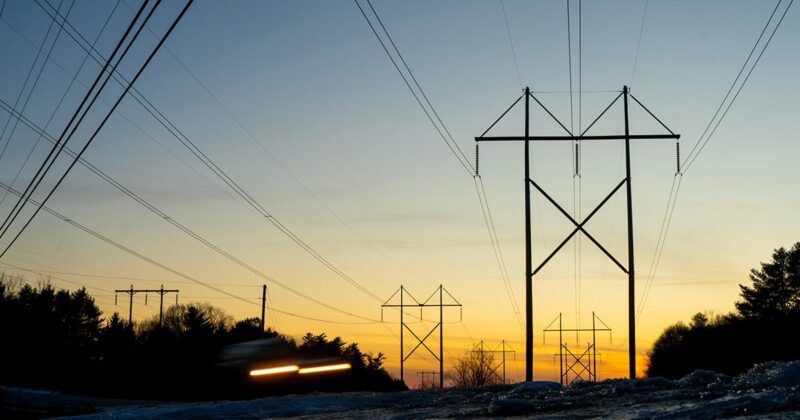 transmission utility lines seen against a yellow sky