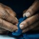 WESTBROOK, ME - OCTOBER 30: Jacques Ndaya of Westbrook, originally from the Congo, works with fabric to make a mitten during a class at the Old Port Wool and Textile School for Stitching, Tuesday, October 30, 2018. (Photo by Gabe Souza for Pine Tree Watch)