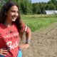 Patience Goulette poses for a photo while standing amid a field of crops.