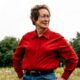 Jean Vermette poses for a photo while standing in a field of wildflowers.