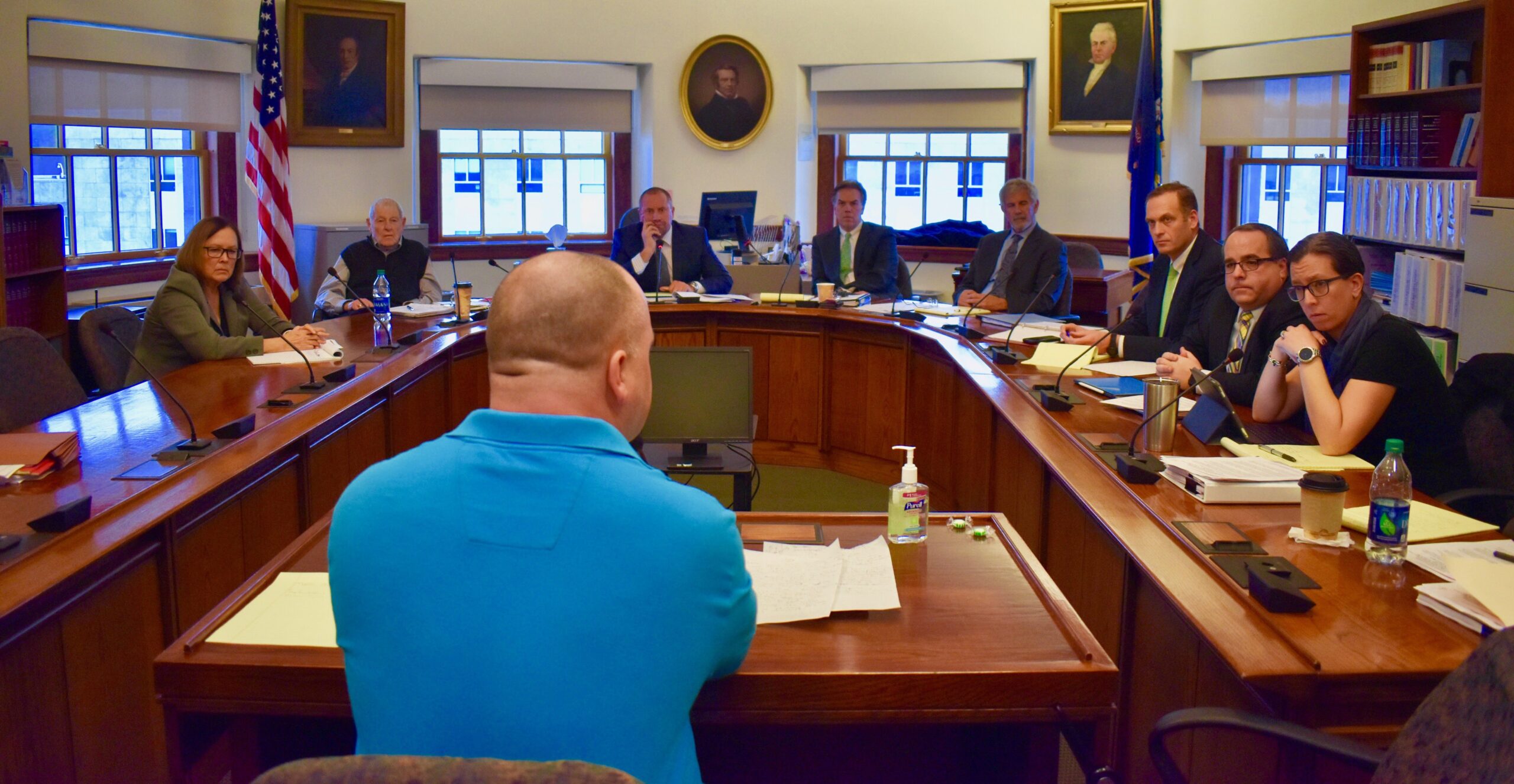 members of a commission listen to the testimony of anthony sanborn