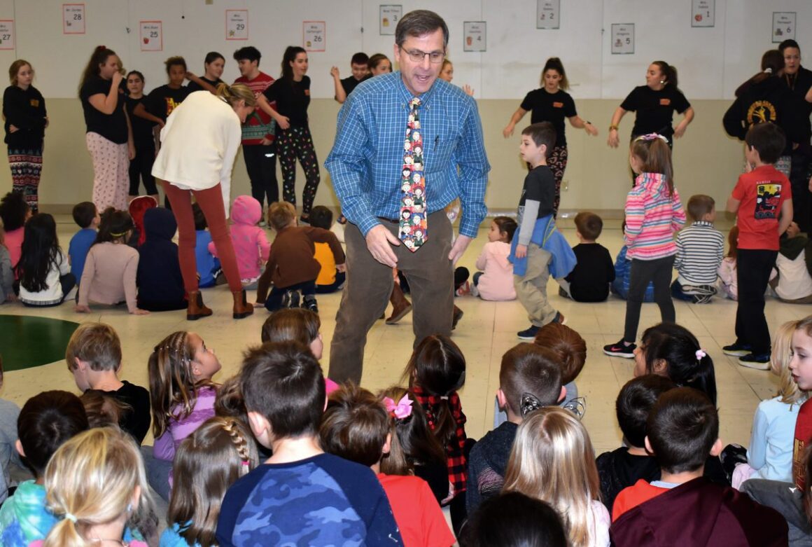 Young School Principal Peter Harrison stands amid a group of students