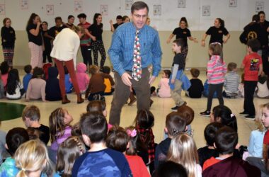 Young School Principal Peter Harrison stands amid a group of students