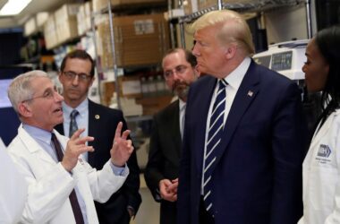 President Donald Trump listens to Dr. Anthony Fauci during a tour