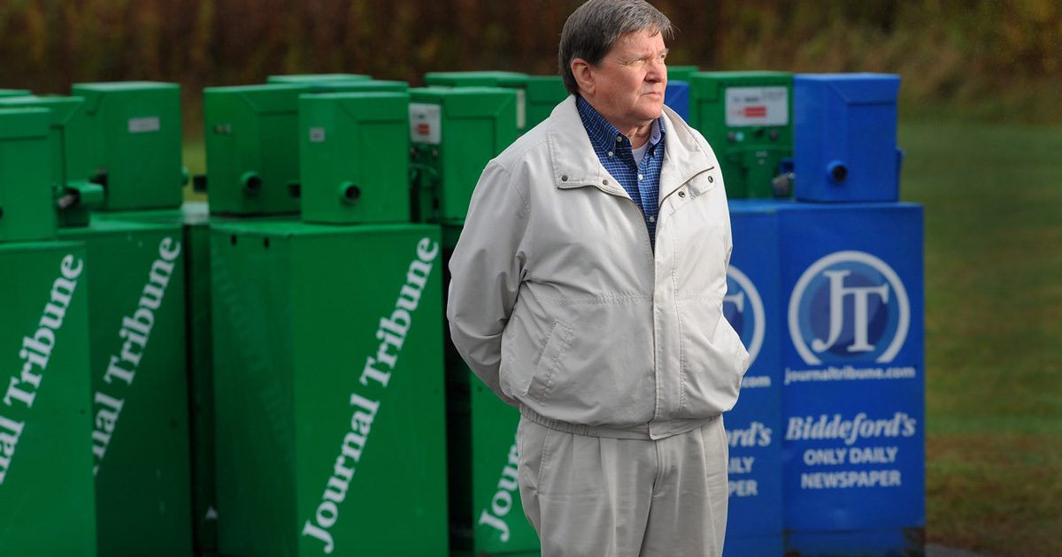 Former Journal Tribune editor Ed Pierce stands next to empty newspaper racks belonging to the Journal Tribune. Photo by Fred J. Field.