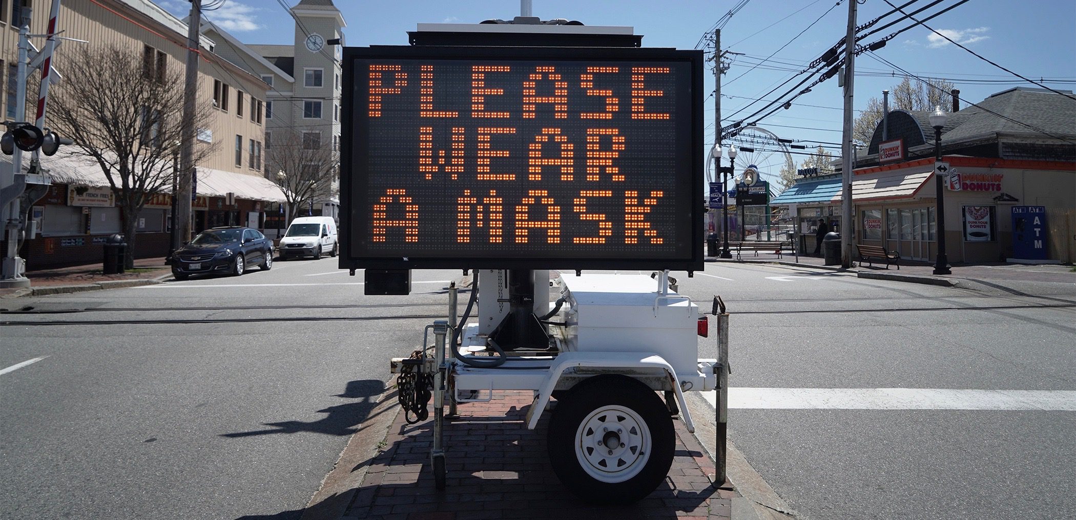 An electronic sign that reads please wear a mask
