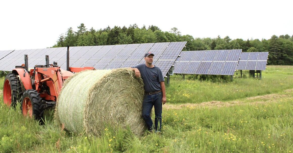 Seth Kroeck poses for a photo against a bale of hay