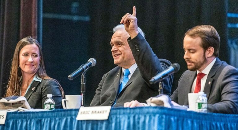 Adrienne Bennett, Dale Crafts and Eric Brakey sit a table during a debate