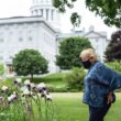 Governor Janet Mills looks at flowers growing in a garden