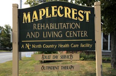 a sign at the entrance to the maplecrest rehabilitation and living center