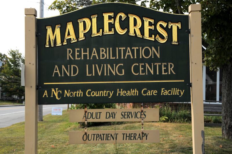 a sign at the entrance to the maplecrest rehabilitation and living center