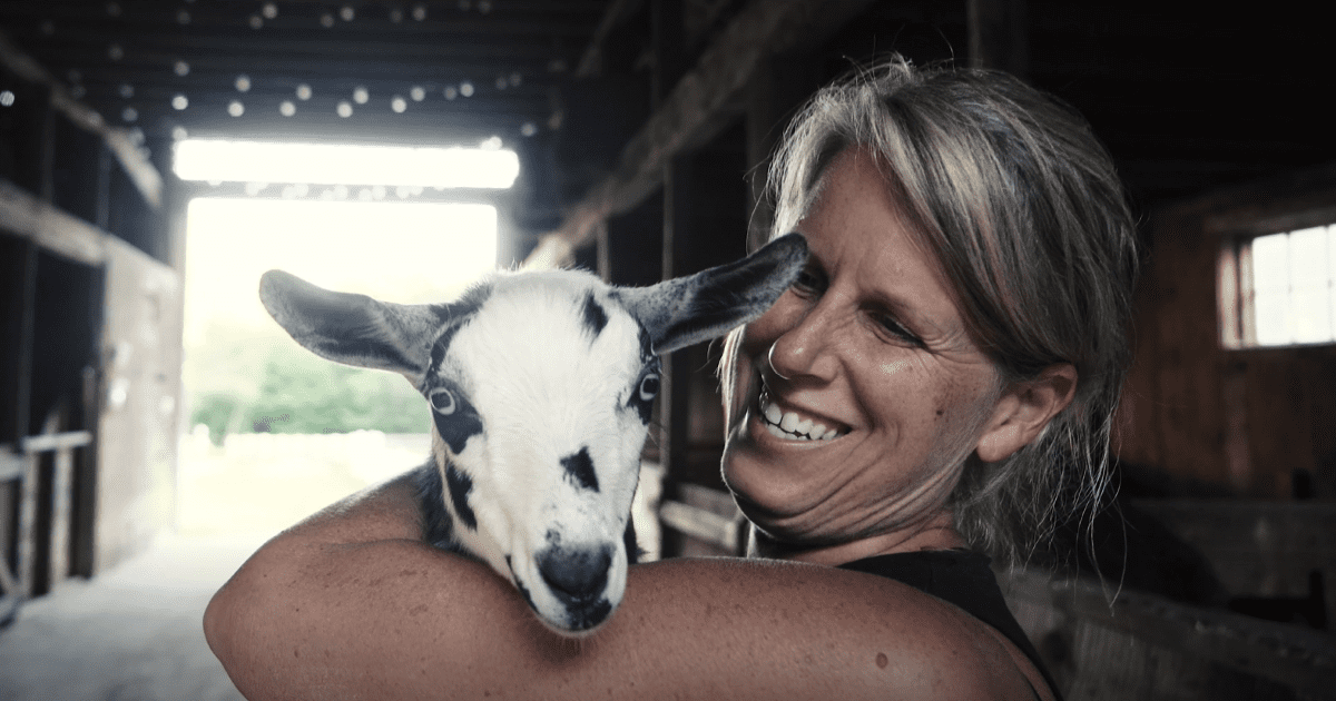 woman holding a goat in her arms