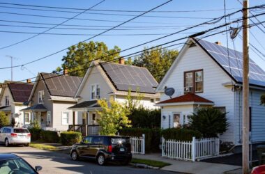 a row of houses with solar panels on the roofs