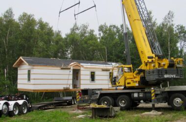 a house hovers in the air while attached to a crane