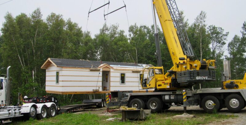 a house hovers in the air while attached to a crane