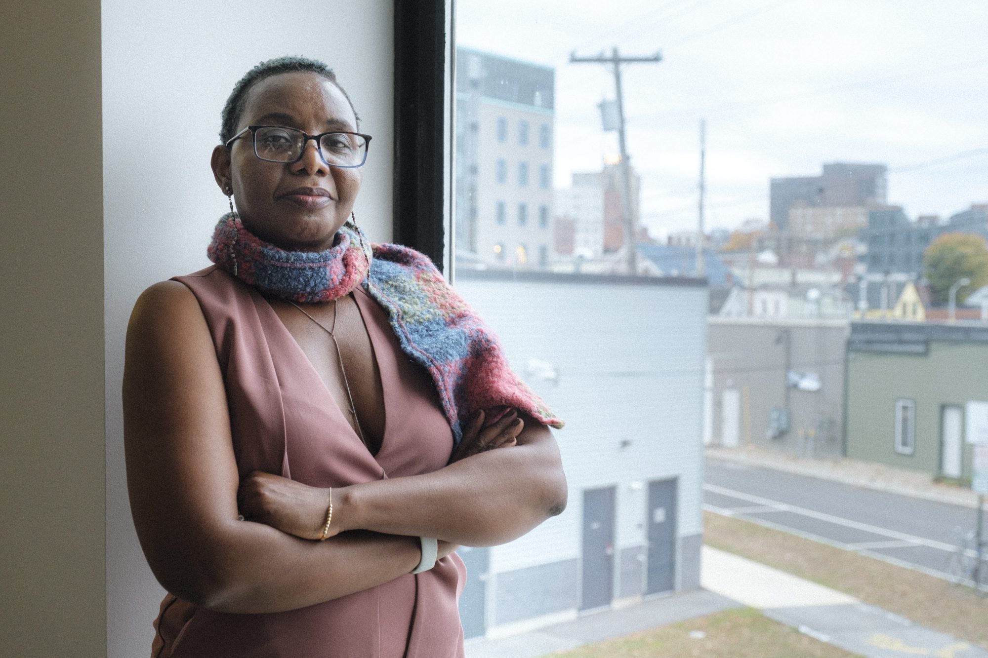 Mufalo Chitam, executive director of the Maine Immigrants’ Rights Coalition, stands in her new office space along Marginal Way in Portland. Chitam helped distribute more than $200,000 in food assistance for the state's communities of color this summer. Photo by Bailey Beltramo.