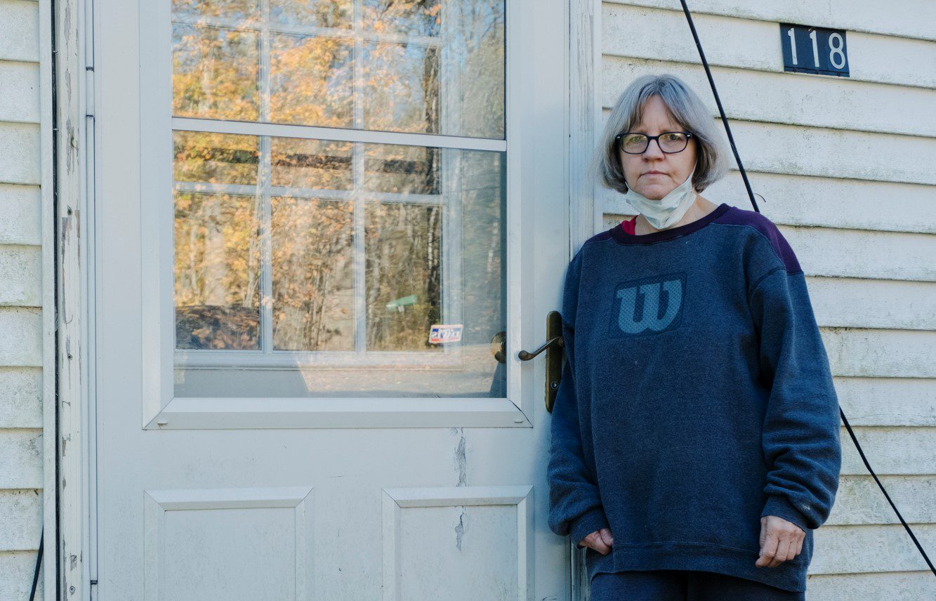 Rebecca Packard poses for a photo while leaning against her closed front door.