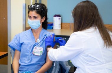 A COVID-19 vaccine is administered to a Maine Health nurse.