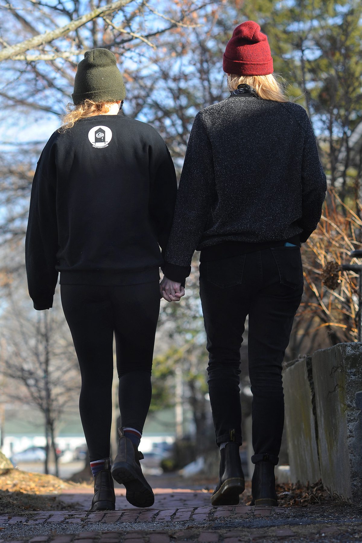 2 women of LGBTQ community holding hands walking on Portland Maine street