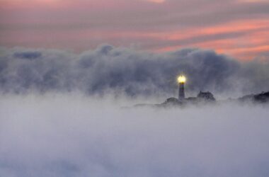 The light of the Portland head light in Cape Elizabeth shines brightly through the fog.
