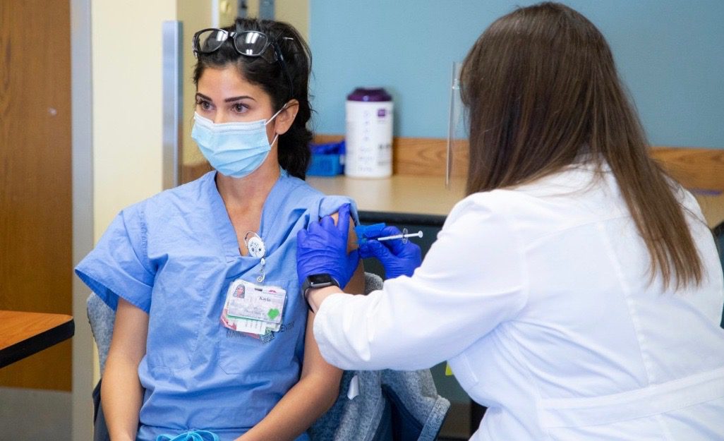 a healthcare employee receives a covid-19 vaccine