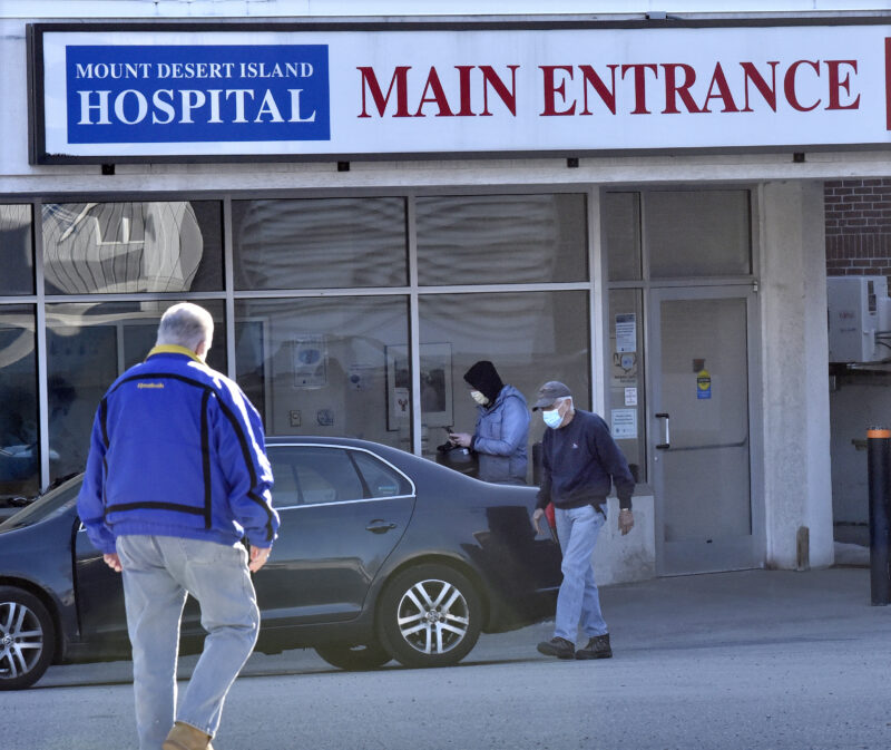 People walk towards and away from the entrance to the Mount Desert Island Hospital.
