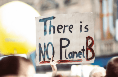 A climate activists hold a climate action sign that reads "There is no Planet B" in protest of emissions.