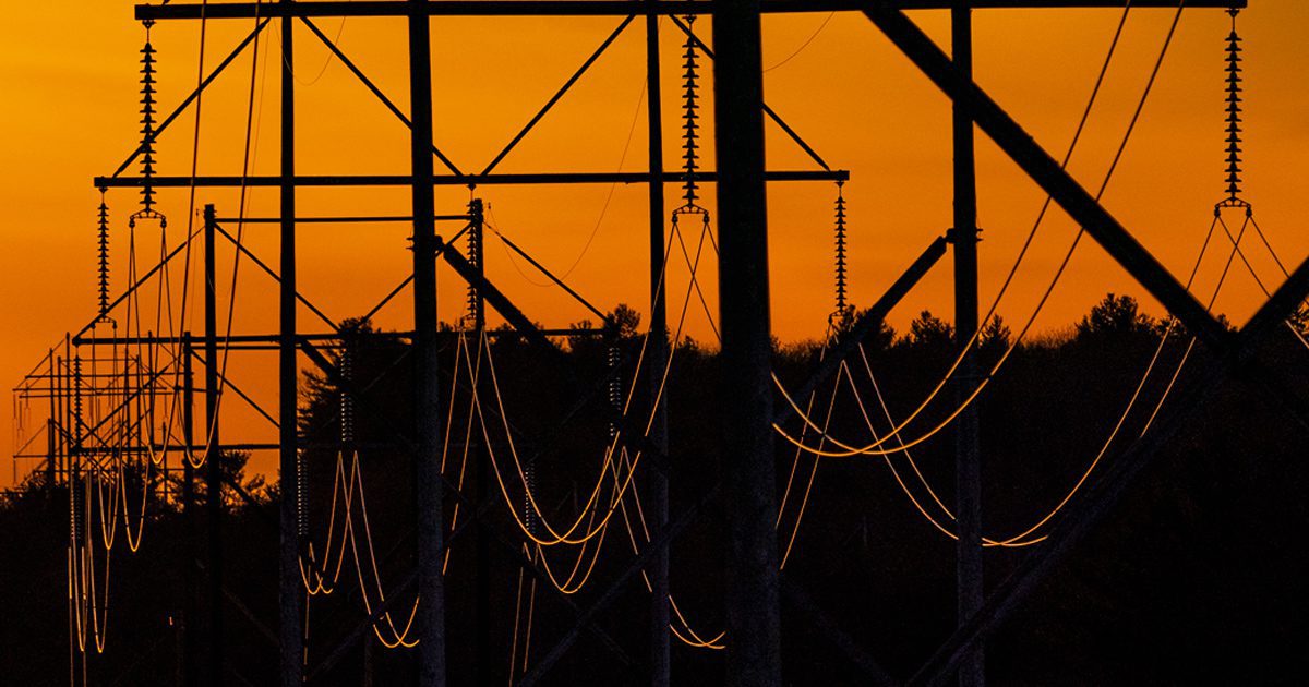 transmission lines seen against an orange sky