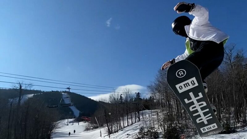 A snowboarder soars through the air.